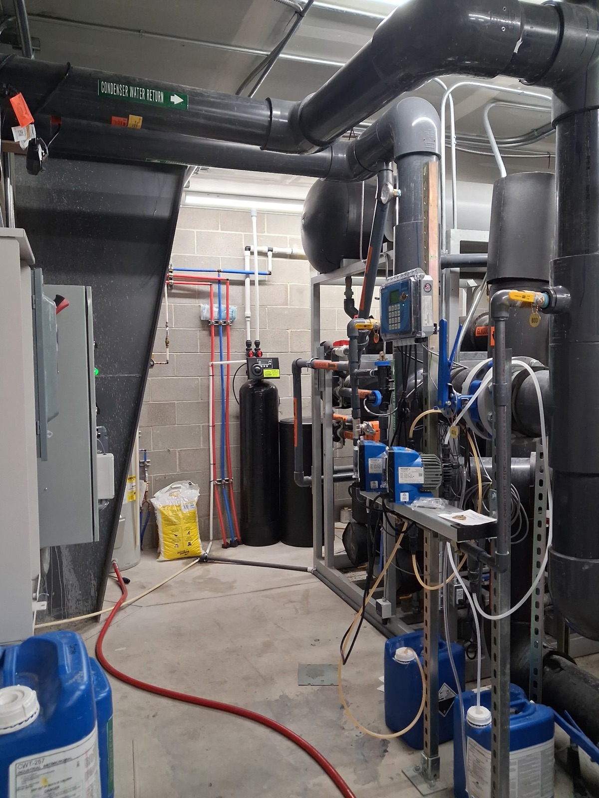 Mechanical room at The Neutral Zone ice rink in Rexburg with the commercial water softener installed among the condenser water and snow-melt systems